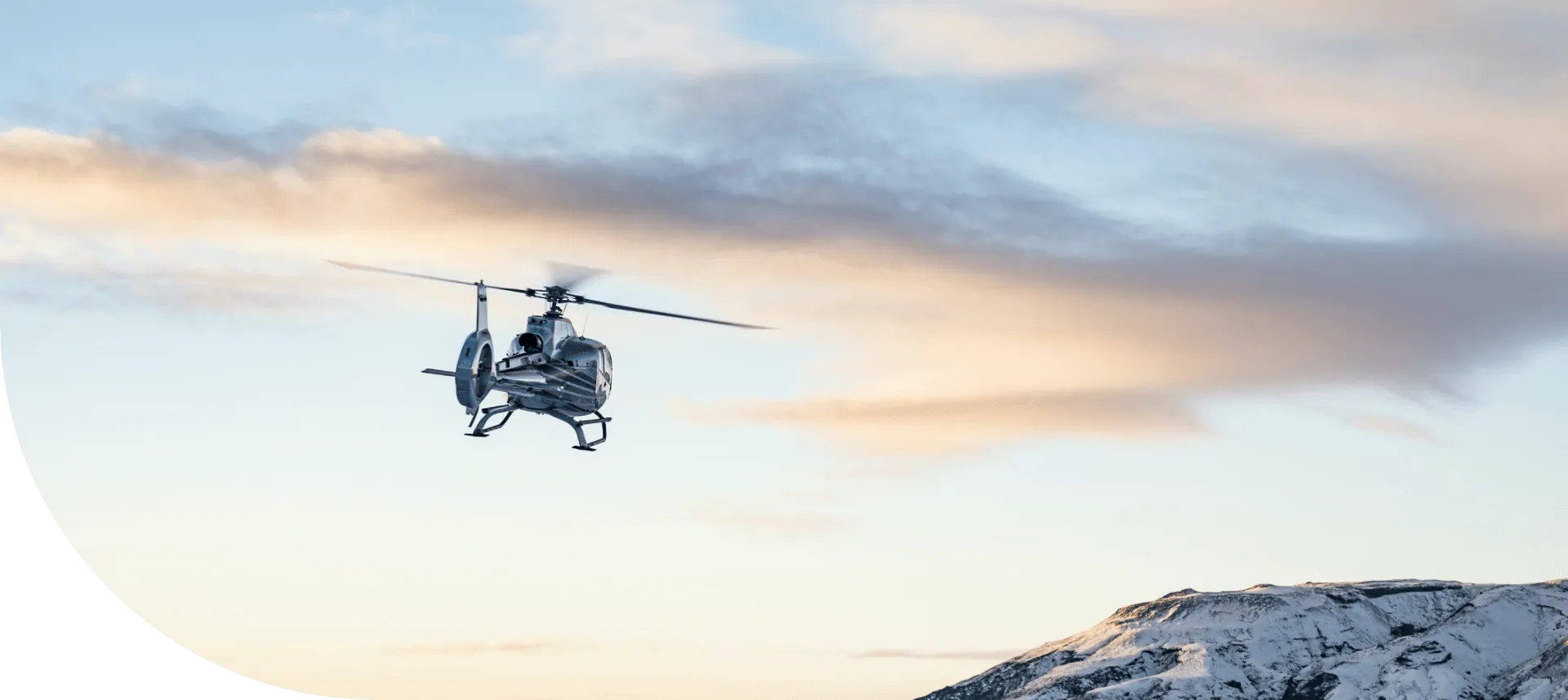 Helicopter flying across a sunset sky