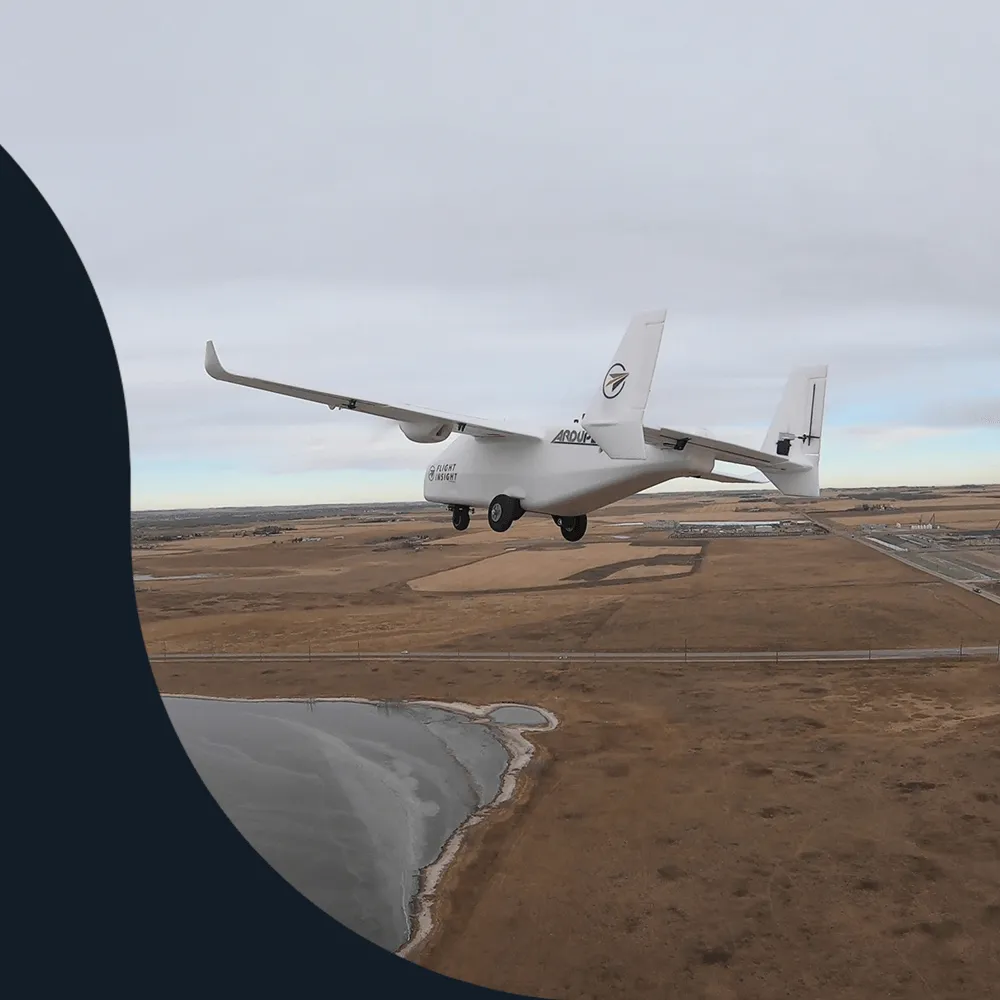 Flight Insight fixed-wing drone carrying EchoTech in flight over Alberta prairie and a frozen lake