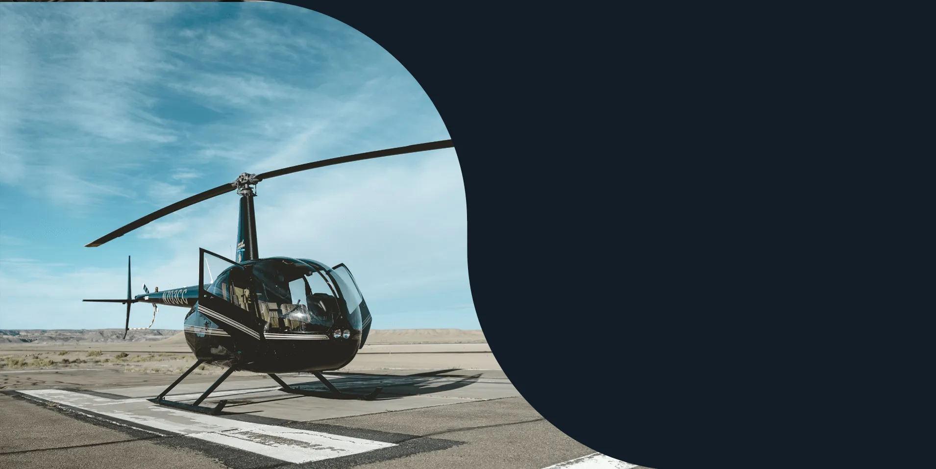 Black helicopter parked on an airfield helipad